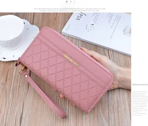 Detail of a pink checkered leather long wallet for women with golden zipper and hand strap