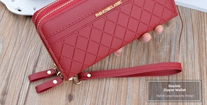 Detail of red quilted faux leather long wallet with double zipper and wrist strap