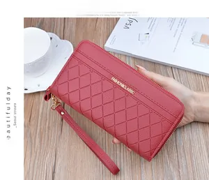 Detail of burgundy long wallet with diamond lattice texture and gold metal logo