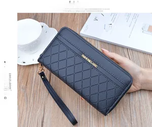 Detail of navy blue quilted long wallet with double zipper and gold hardware on a table