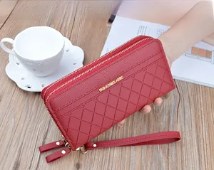 Detail of red quilted long wallet with double zipper and golden metal fashion logo