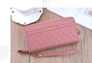 Detailed macro view of pink checkered double zip wallet with gold logo on wooden surface