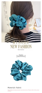 Detailed view of teal satin scrunchie fabric texture and back view of hair accessory