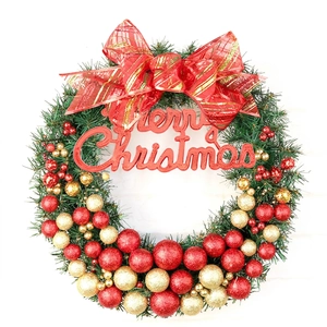 Christmas wreath with green pine needles, red gold glitter baubles and bow decoration
