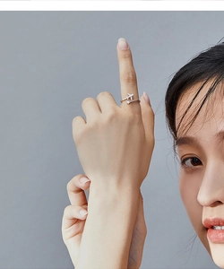 Close-up of 925 sterling silver airplane and star open ring worn on model finger
