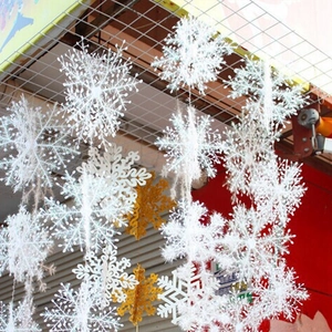 Detailed close-up of white and gold 3D plastic Christmas snowflake hanging ornaments