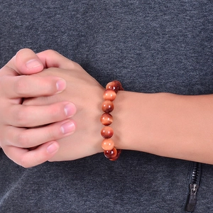 Natural red tiger eye stone beaded bracelet with glossy chatoyant finish on wrist