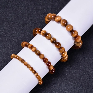 Three sizes of natural yellow tiger eye beaded bracelets displayed on a neutral stand