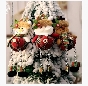 Three Christmas plush ornaments with plaid fabric and bead legs hanging on a tree branch