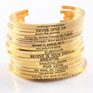 Stack of gold stainless steel mantra bracelets with engraved inspirational quotes