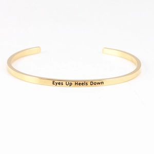 Polished gold stainless steel open Mantra Bracelet with Eyes Up Heels Down engraving