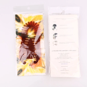 Brown plastic banana hair clip packaging with Spanish instructions and comb design detail