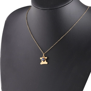 Detail of gold constellation necklace with H-shaped pendant and inlaid blue birthstone