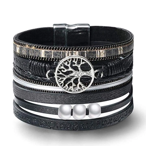 Macro view of multi-layer leather bracelet with tree of life charm and magnetic clasp