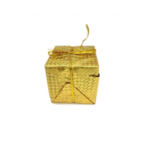 Close-up of golden Christmas gift box ornament with shiny ribbon and textured wrapping