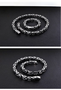 Macro detail of men's stainless steel Byzantine chain necklace with woven ring texture