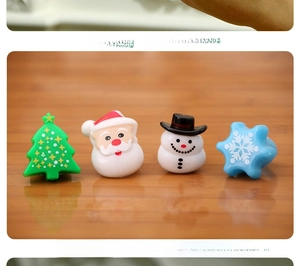 Macro detail of Christmas finger rings featuring Santa, snowman, and tree on wood