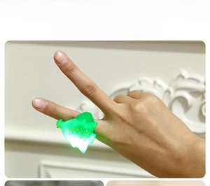 Detail shot of a glowing LED Christmas tree ring with star on a finger for holiday parties