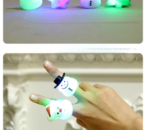 Detail of Christmas LED glowing rings featuring Santa and snowman patterns on fingers