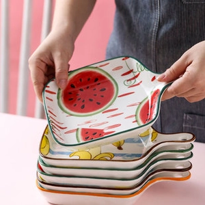 Detalle de platos cerámicos coloridos con asas y vibrantes patrones de frutas