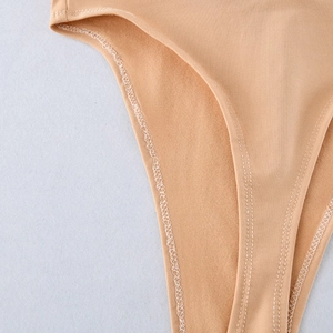 Close-up of the smooth peach fabric and refined stitching on the jumpsuit crotch area