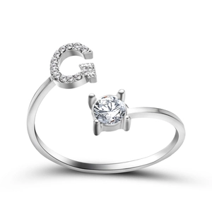 Detail of adjustable silver ring featuring pave letter G and a round solitaire crystal
