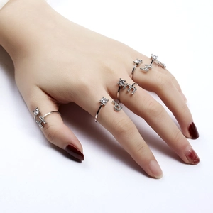 Detailed view of silver letter rings with sparkling rhinestones worn on a hand