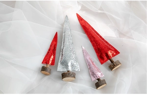 Macro shot of glitter Christmas trees in red, silver and pink with natural wood bases