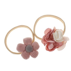 Detail of pink and white fabric flower headbands for babies on a clean white background