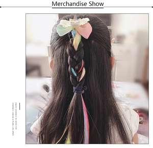 Rainbow hair extension clip on a young girl showing long colorful fiber strands