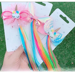 Detail of unicorn hair clips with sequin bows and colorful gradient hair extensions