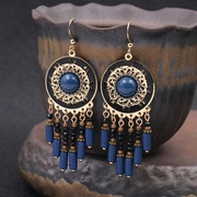 Gros plan détaillé de boucles d'oreilles bohèmes avec pierres bleues et métal vintage