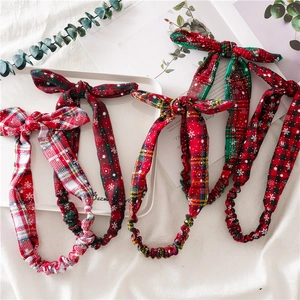 Detail view of four Christmas plaid headbands with snowflake patterns and elastic bands