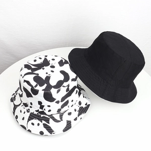 Detail of reversible panda bucket hat showing white cartoon pattern and solid black cotton
