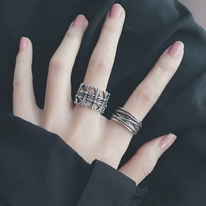 Primo piano di anelli impilabili in argento vintage con motivi a croce traforati su mano