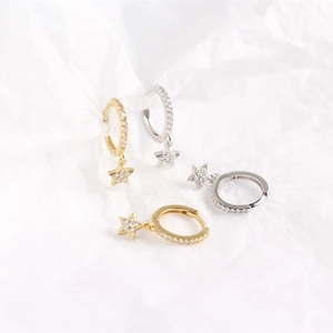 Detail view of gold and silver S925 sterling silver star hoop earrings with small crystals