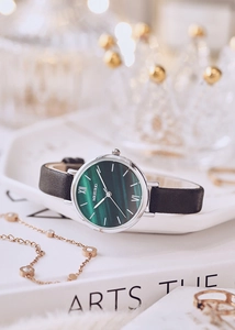Close-up of a green malachite dial watch with silver case and black leather strap