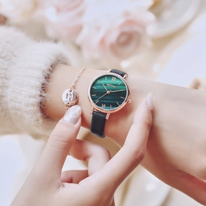 Elegant ladies watch with green marble dial and black leather strap worn with bracelet