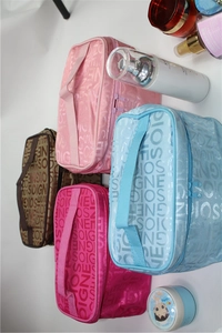 Detailed top view of four large portable toiletry bags in pink, blue, rose, and brown colors