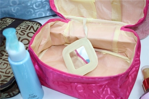 Detail of travel makeup bag featuring interior folding mirror and embossed lettering