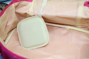 Detail view of pink makeup bag interior featuring elastic bands and mesh compartments