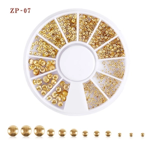 Detailed set of gold metal nail art beads in various sizes within a white storage box