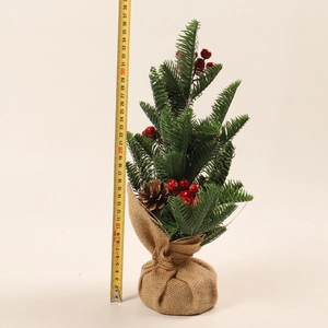 Detailed view of a 36cm mini Christmas tree with red berries, pine cones and burlap base