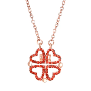 Rose gold clover necklace with four folding hearts and red crystals on white background