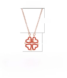 Detail of rose gold clover necklace featuring magnetic folding heart pendant with crystals