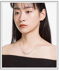 Silver heart-shaped interlocking necklace with sparkling crystals on model's neckline