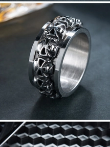 Detailed macro view of punk stainless steel ring with relief skull pattern and brushed texture