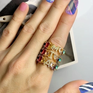 Gold letter M I A rings with colorful heart and rectangle zircon stones on a female hand