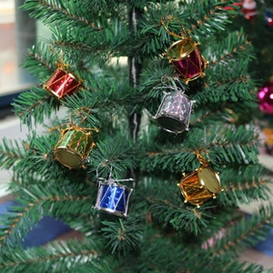 Close-up of colorful mini drum ornaments hanging on a Christmas tree for festive decoration
