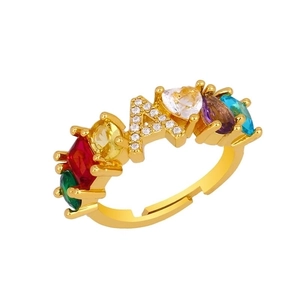 Detailed macro view of gold letter A ring with colorful heart and oval zircon stones